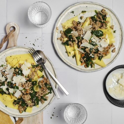 Two plates of Gluten-Free Blonde Bolognese on a stoneware plates ready to serve.