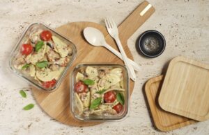 Two glass serving dishes filled with Summer Carbonara ready to be taken for a work lunch.