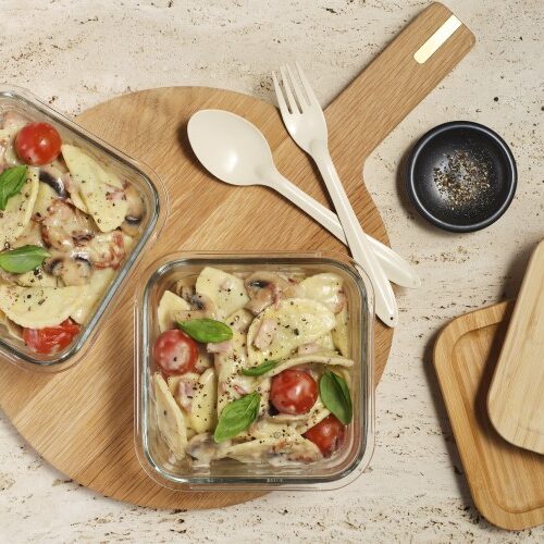 Two glass serving dishes filled with Summer Carbonara ready to be taken for a work lunch.